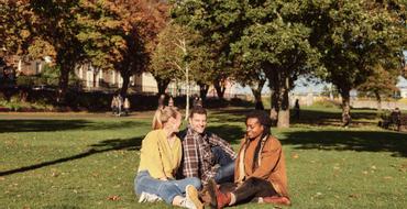Trinity City Hotel |  | Keep Discovering Dublin - 20% Off | 2 women and a man sitting in people's park in Dun Laoghaire during autumn surrounded by fallen leaves